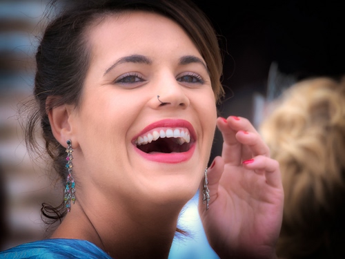 Immagine con denti, mano, sorriso, occhi, donna, ritratto, bocca, ridere, orecchini, labbra, naso, rossetto, capelli, viso, sfocato, unghie, rosso, orecchio, mani, volto