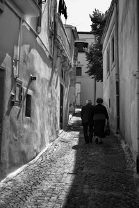 vicolo, bianconero, anziani, due, finestre, persone, coppia, borsa, case, ombre, ombra, alberi, passanti, strada, porte, porta, muri, selciato, borgo