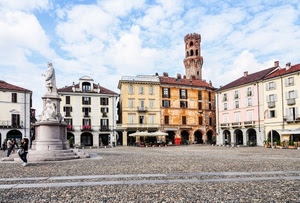 piazza, monumento, torre, portici, palazzi, statua, finestre, archi, cielo, nuvole, persone, tetti, case, ombrelloni, merli, balconi, selciato