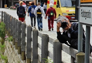 fotografo, staccionata, giallo, legno, furgone, persone, strada, pali, cartello, rosso, fotografa, verde, passanti, parapetto, fotocamera, scritta