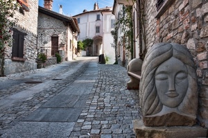 case, strada, finestre, vicolo, panchina, via, porte, sculture, scultura, borgo, pietre, paese, viso, pietra, piante, tetti, scorcio, panca, cielo, statua, mattoni, salita